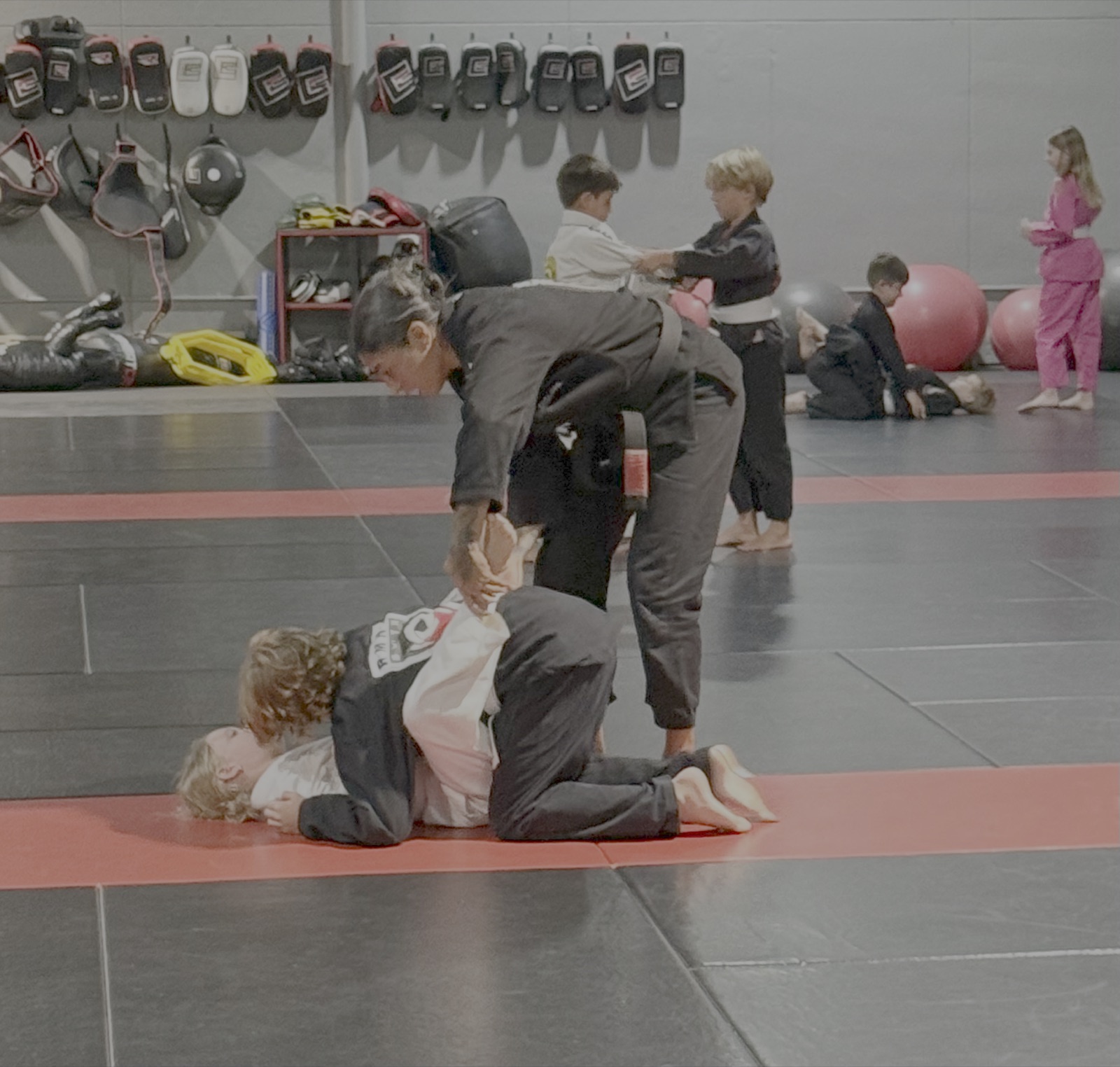 Coach guiding a young student through a technique in Kids Jiu-Jitsu at South Tampa Jiu-Jitsu