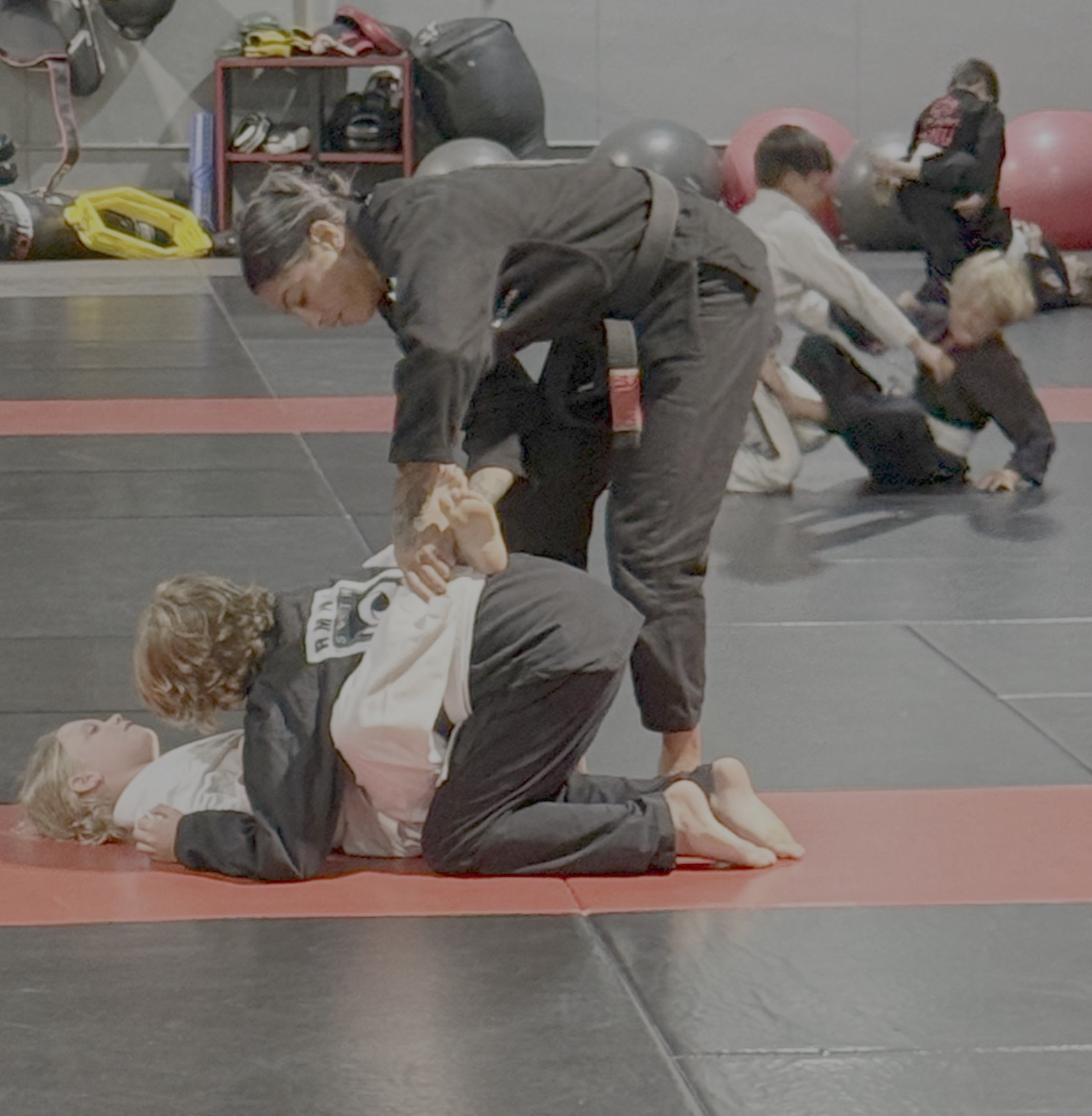 Coach guiding a young student through a technique in Kids Jiu-Jitsu at South Tampa Jiu-Jitsu