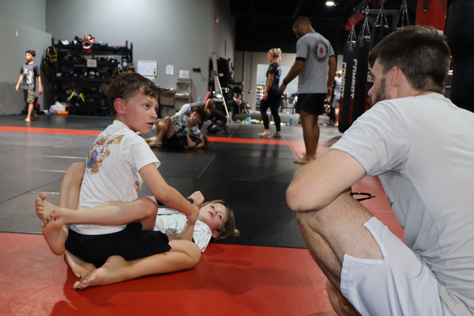 Coach guiding a young student through a technique at South Tampa Jiu-Jitsu