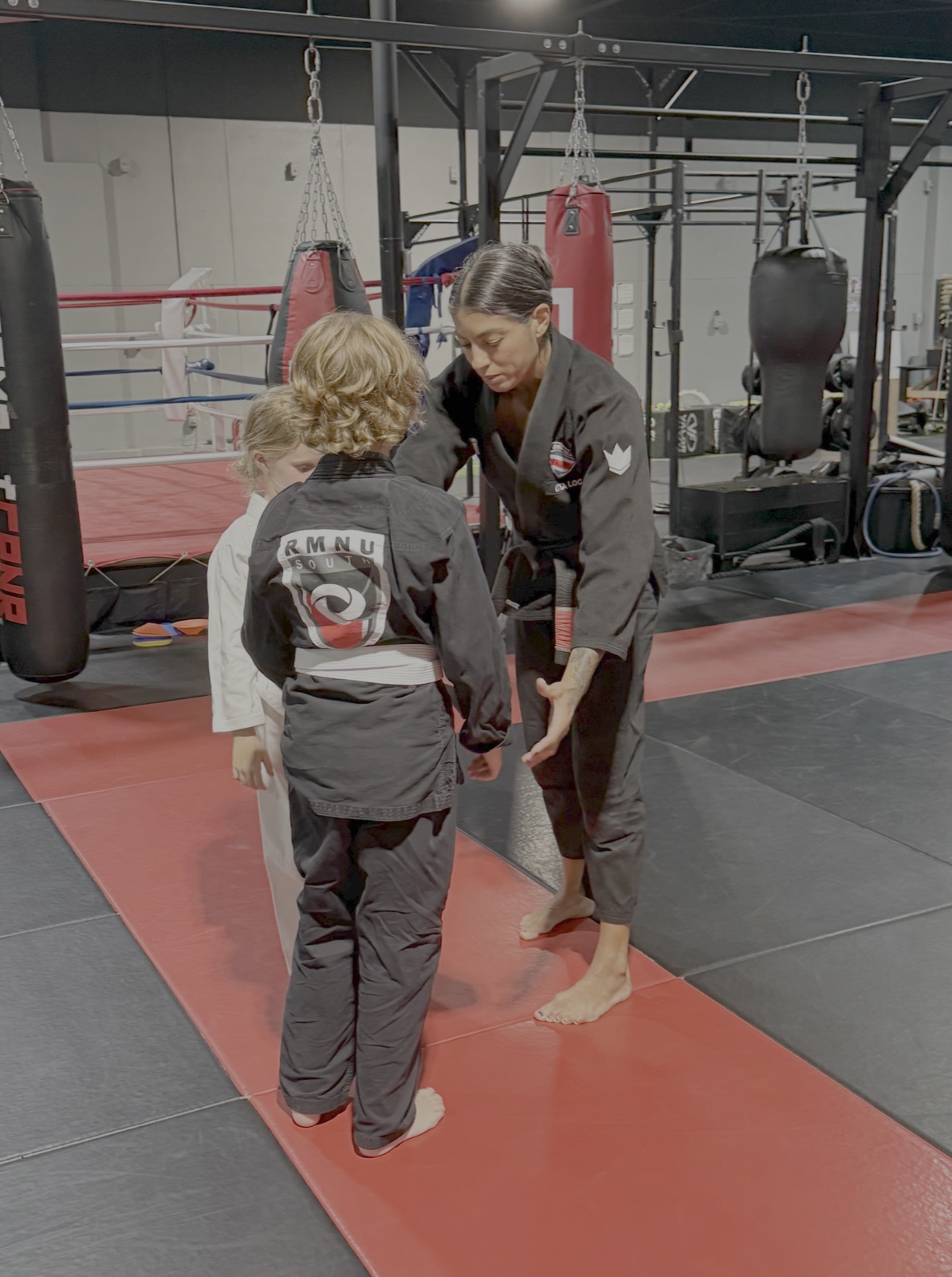 Instructor coaching two young Tiny Ninjas students at South Tampa Jiu-Jitsu